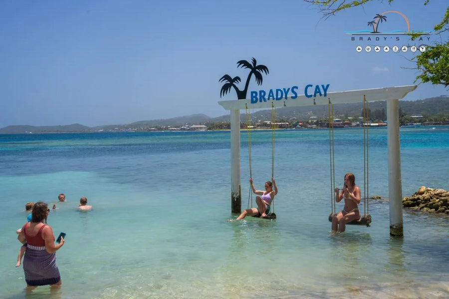 Swings in the shallow water under the Brady's Cay sign in Roatán